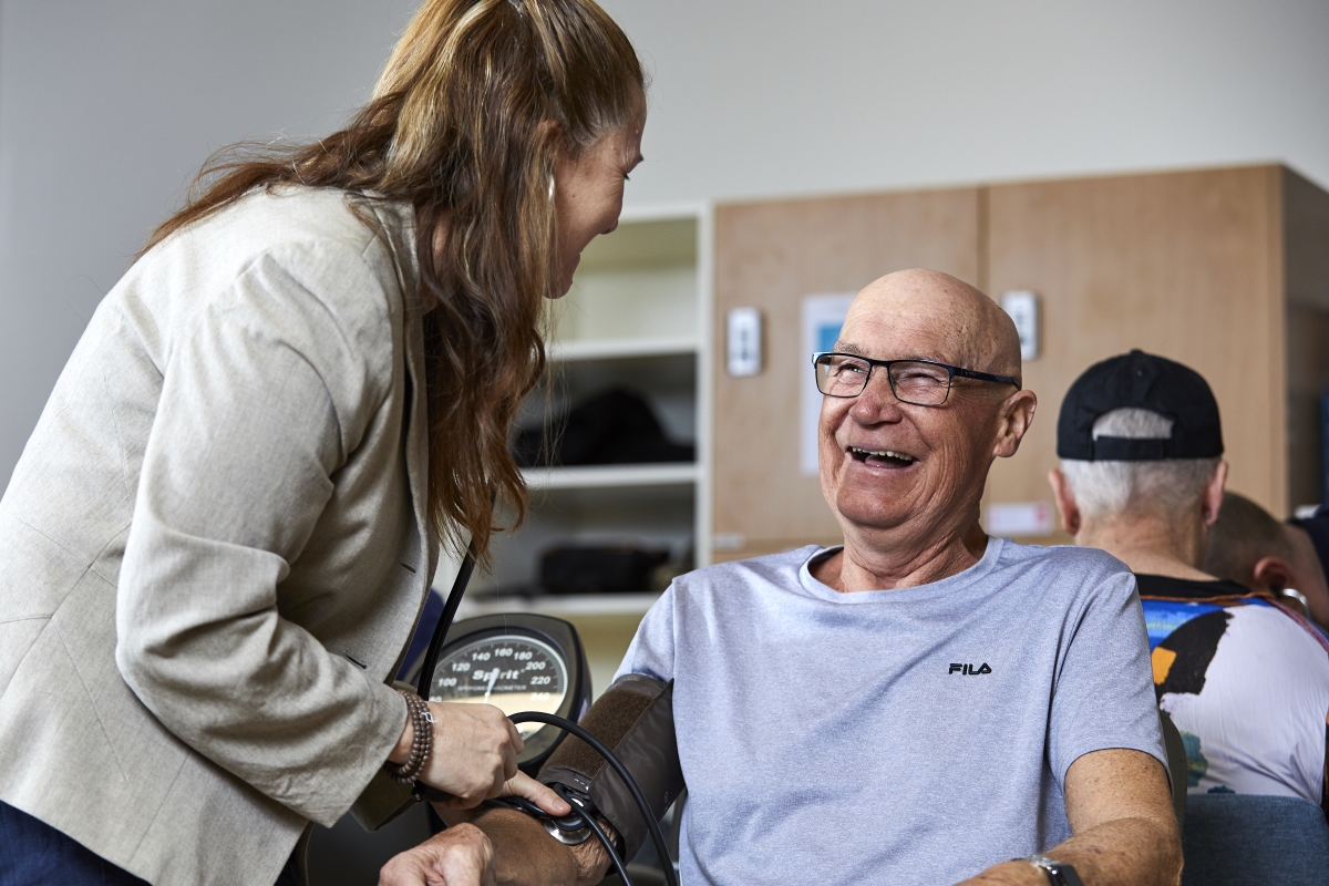 An elderly man having his blood pressure taken by a nurse as part of Cancer Wellness Research at UC Health Clinics