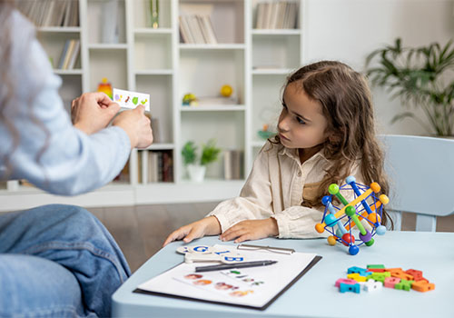 A speech pathologist working with a child at the UC Health Hub.
