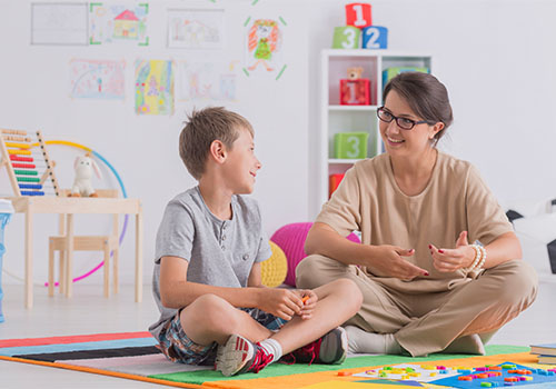 A speech pathologist working with a child at the UC Health Hub.