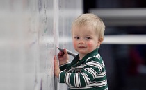 preschool boy drawing on whiteboard